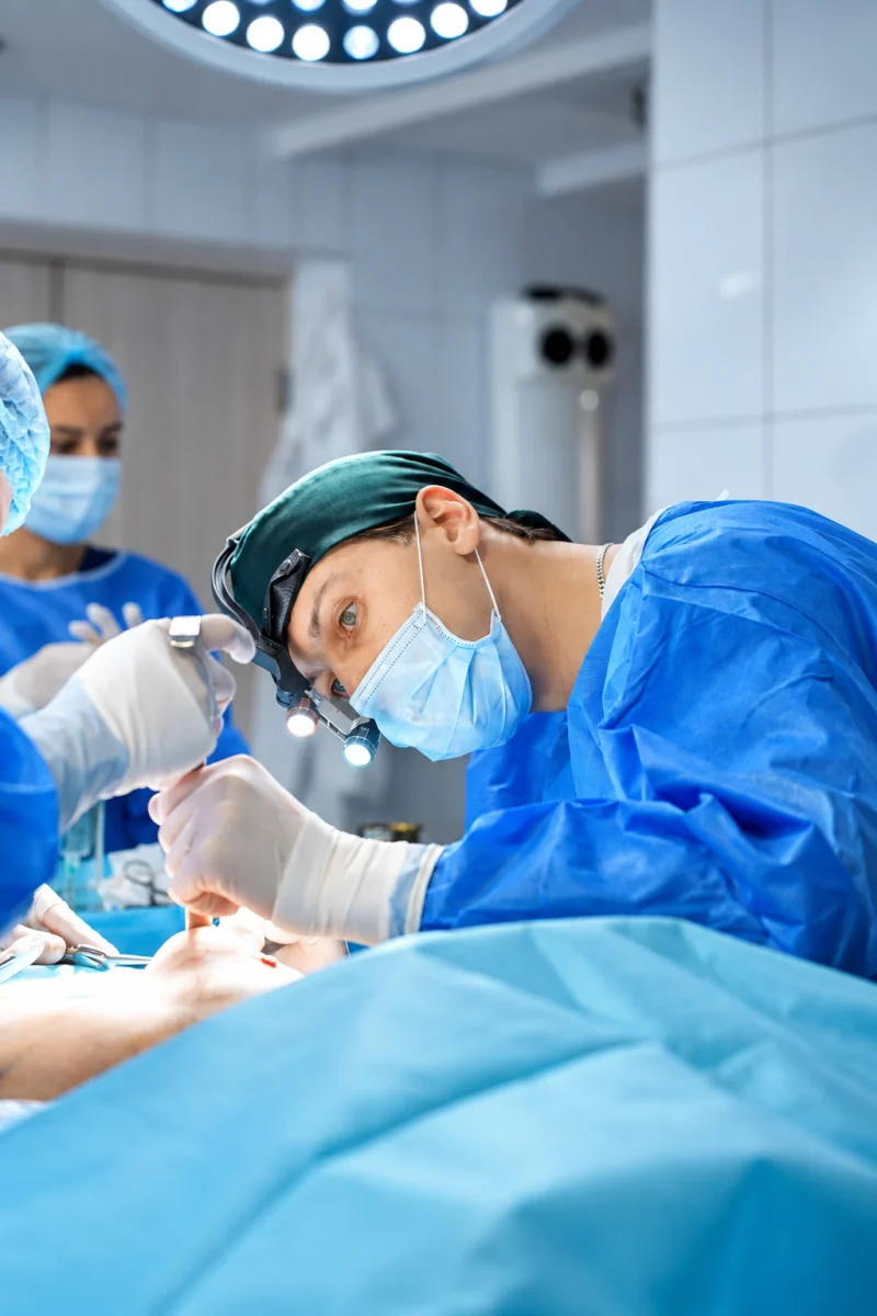 A plastic surgeon during breast augmentation surgery
